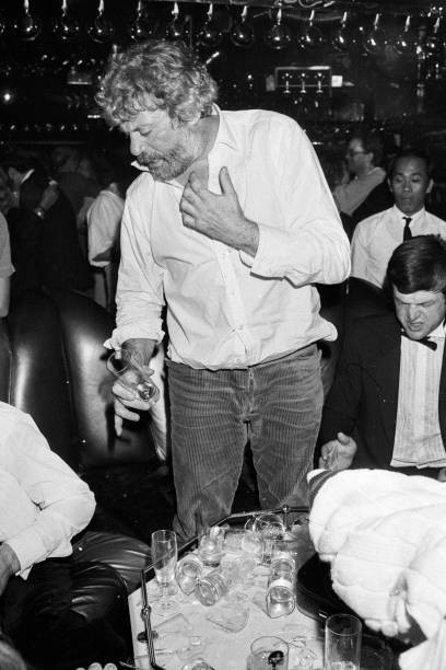 Oliver Reed balancing glasses top of each other at his girlfriends- Old Photo 2