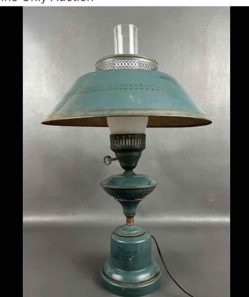 A vintage green toleware table lamp with a decorative metal base.