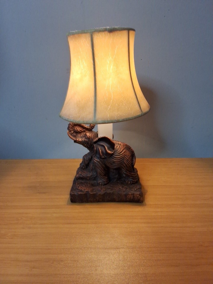 Small Resin Bronze- Colored Elephant Trunk Up Table Lamp With Cream Shade. Works