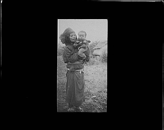 Ainu woman holding child outside,villages,lantern slides,Arnold Genthe,1908