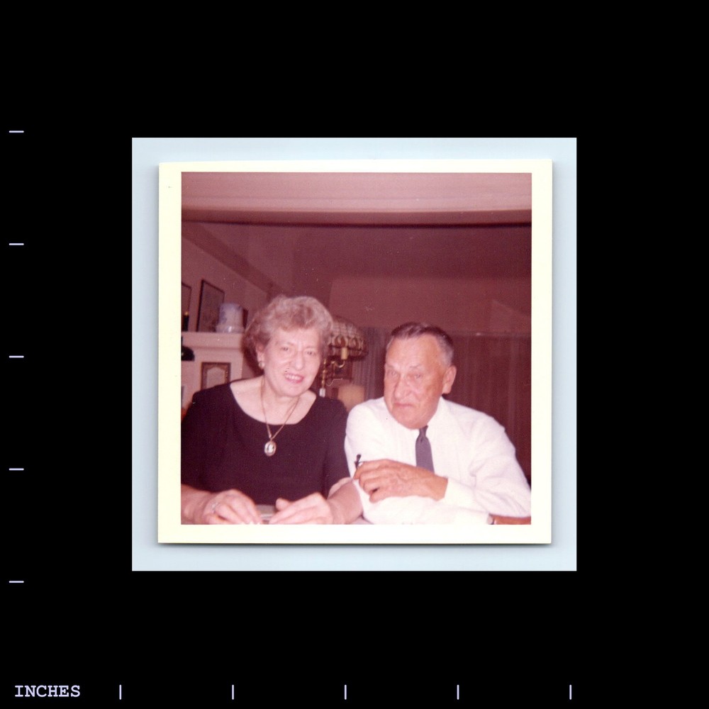 Square Color Photo MAN AND WOMAN SITTING IN ROOM