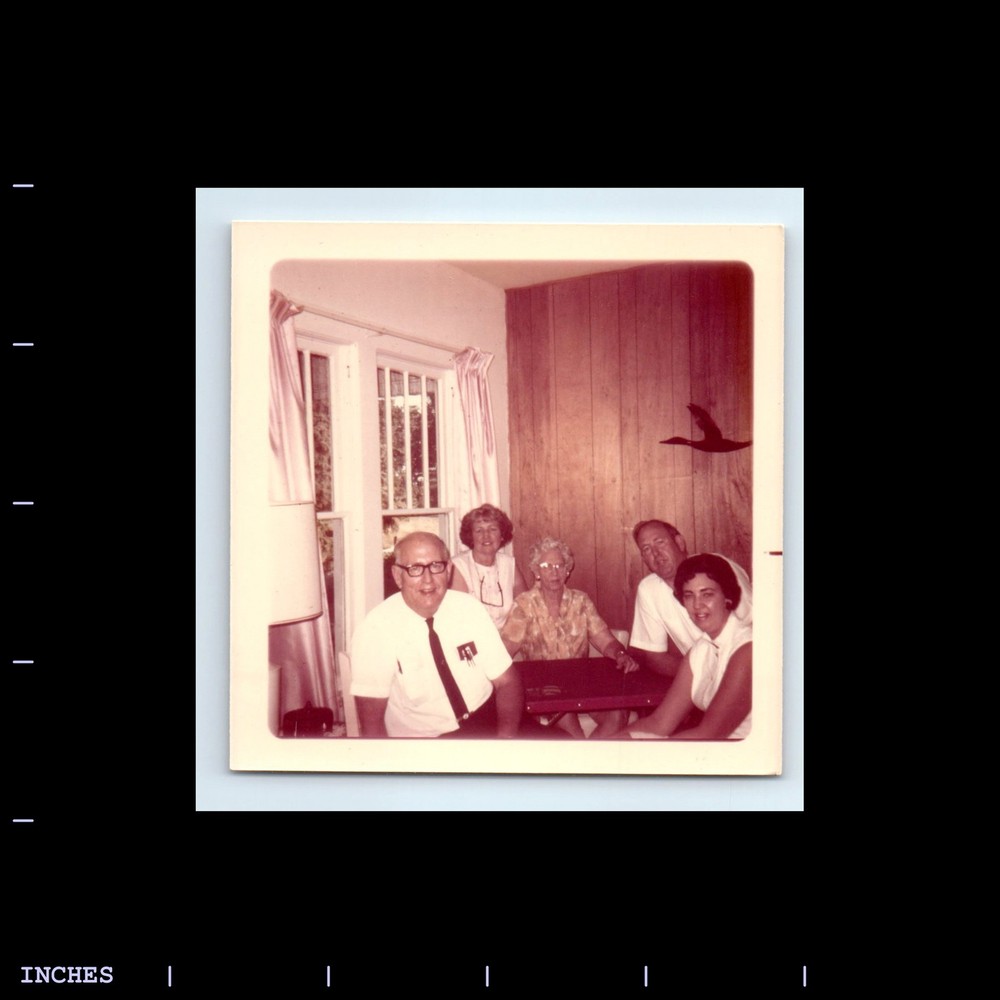 Square Color Photo MEN AND WOMEN SITTING IN LIVING ROOM
