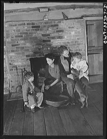 Photo:Family by Brick Fireplace 1900s Interior Portrait With Dog