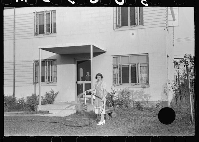 Photo:Greenbelt Maryland 1938 Apartment House Woman Watering Lawn
