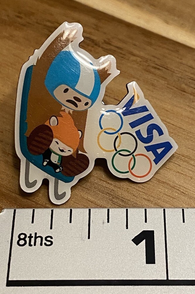 Olympic Games Pin 2010 Vancouver Bobsled VISA Sponsor Mark Mascot Hat Lapel