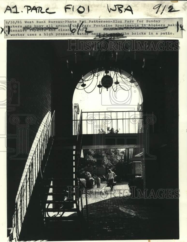 1981 Press Photo Worker pressure washes Parc Fontaine Apartment patio.