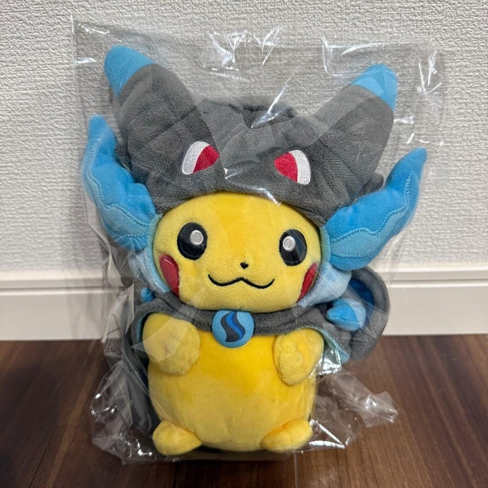 Pikachu plush toy wearing a poncho from Mega Charizard X #70fa5c