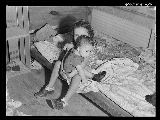 Photo:1930s Mother Holding Child on Bed Cabin Interior Untitled 8816