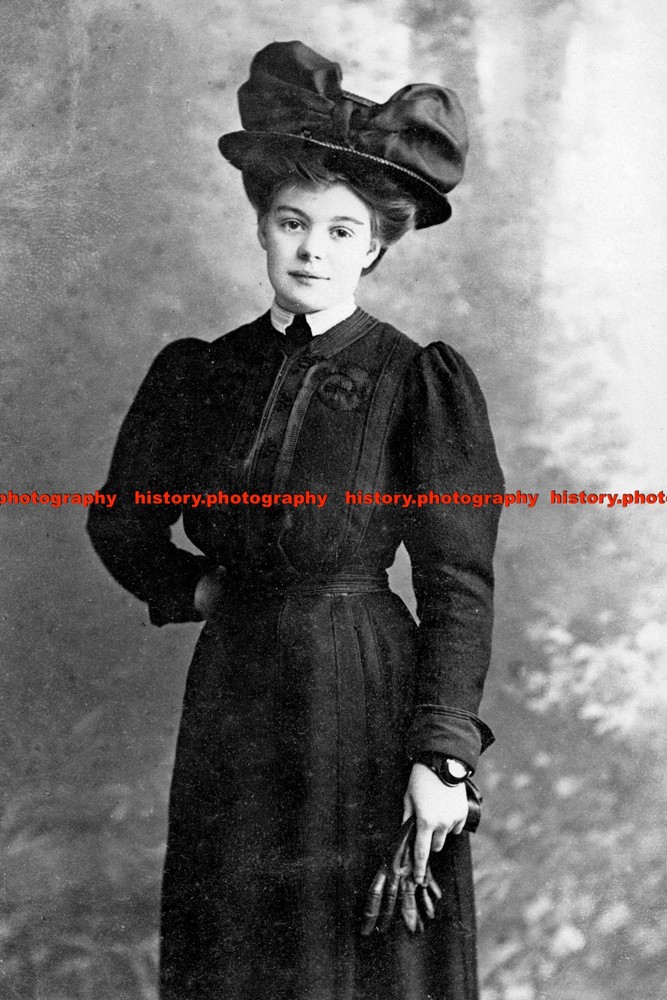 F006169 A woman with a hat in a long black dress with gloves in her hands