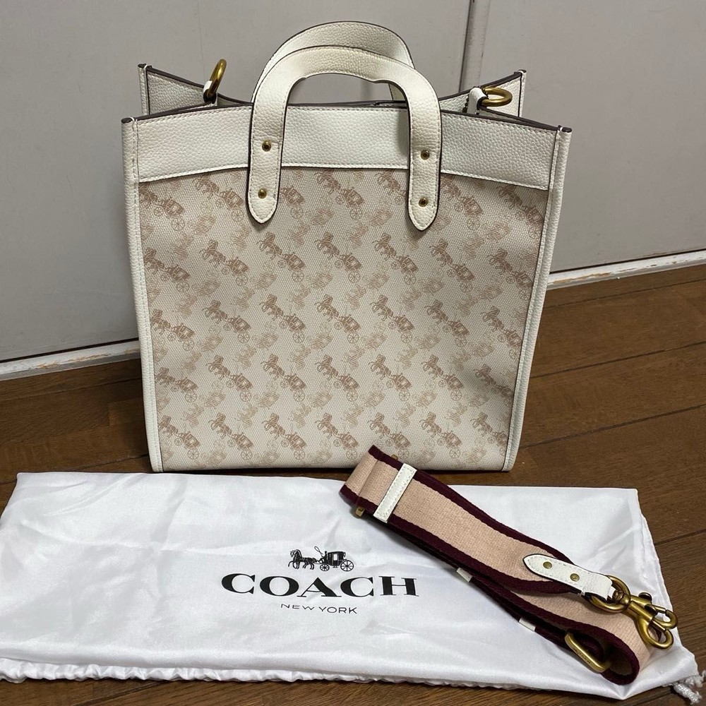 COACH signature leather tote bag with polished hardware and spacious interior