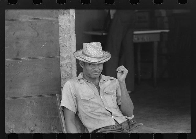 Photo:1930s Man in Straw Hat Sitting Outside Store Portrait