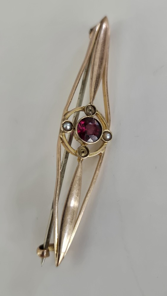 Victorian 9K gold bar brooch with central garnet flanked by seed pearls