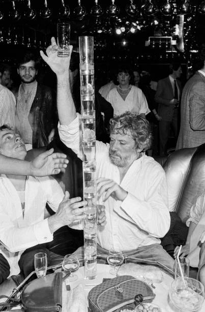 Oliver Reed balancing glasses top of each other at his girlfriends- Old Photo