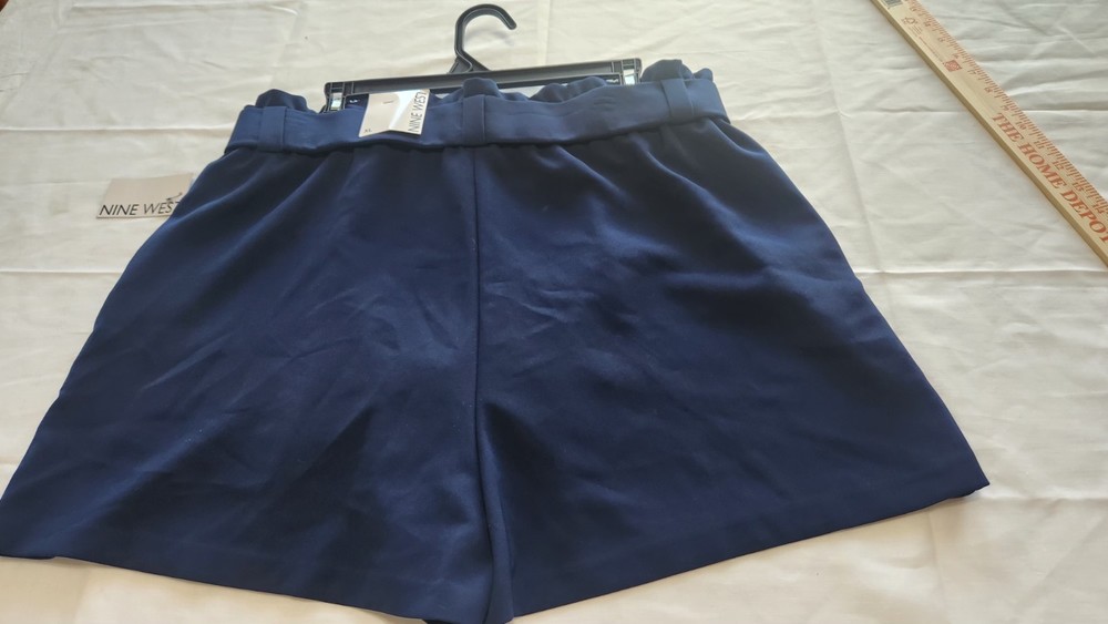 Nine West navy blue high-waisted shorts a belted waist and pleated details.