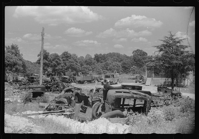 Photo:1930s Junkyard Scrap Cars Trucks Rural Scene Trees Cloudy Sky