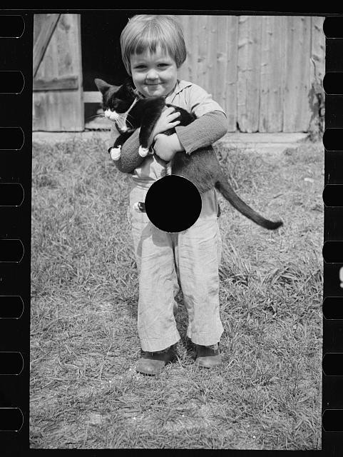Photo:1930s Boy Holding Black and White Cat Outdoor Snapshot