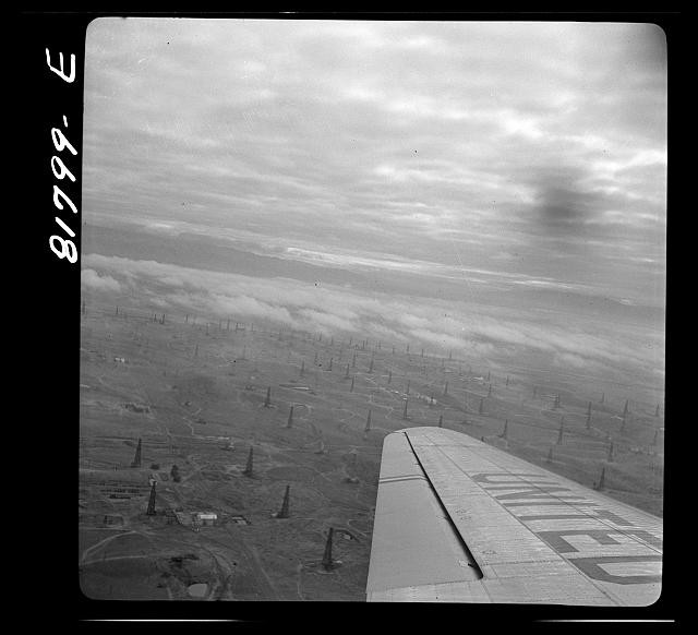 Photo:1930s Oil Field Aerial View Airplane Wing Smoke Plumes Oil Derricks