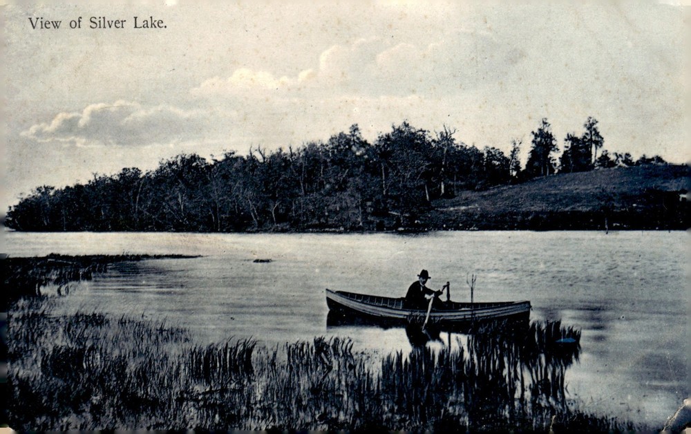 1912 Silver Lake West Bend Wisconsin M.F. Schloemer Man in Rowboat Postcard