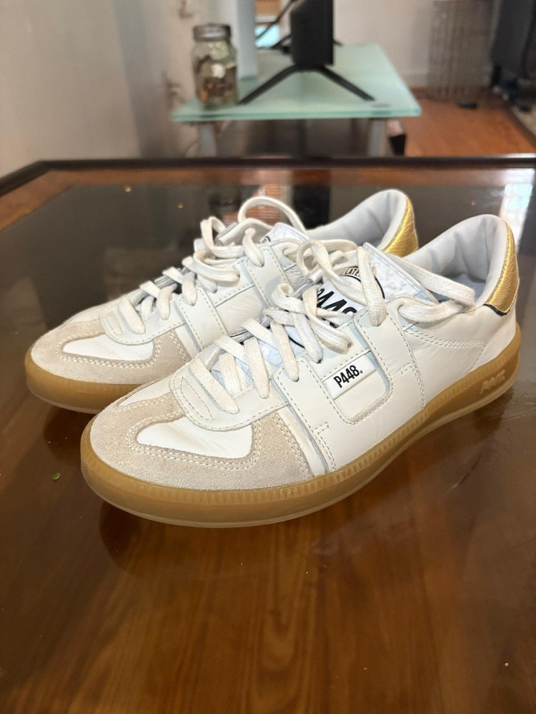 P448 John sneakers with white leather and gold accents.