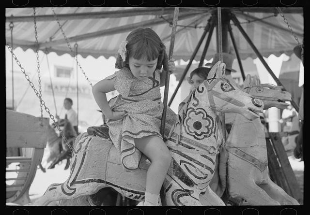 Photo:Little girl on the merry-go-round horse. Fiesta, Taos, New Mexico