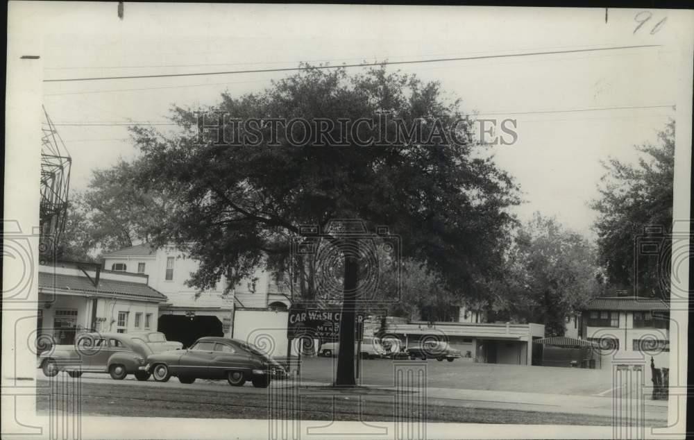 1956 Press Photo St. Charles Avenue car wash sits beside widespread oat tree.