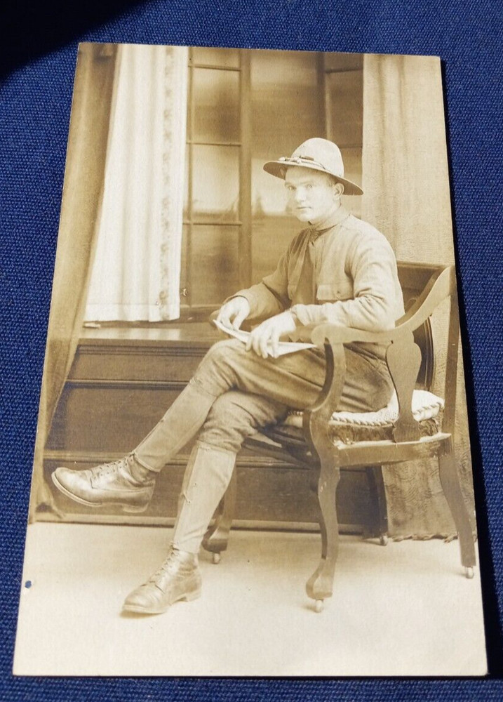 Antique WWI era RPPC POSTCARD Military Soldier Uniform Sitting in Chair Posing