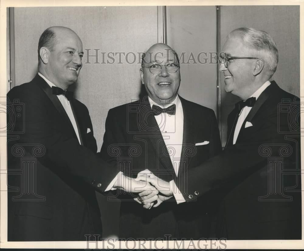 Press Photo Herve Racivitch between men shaking hands at Event - noc33753