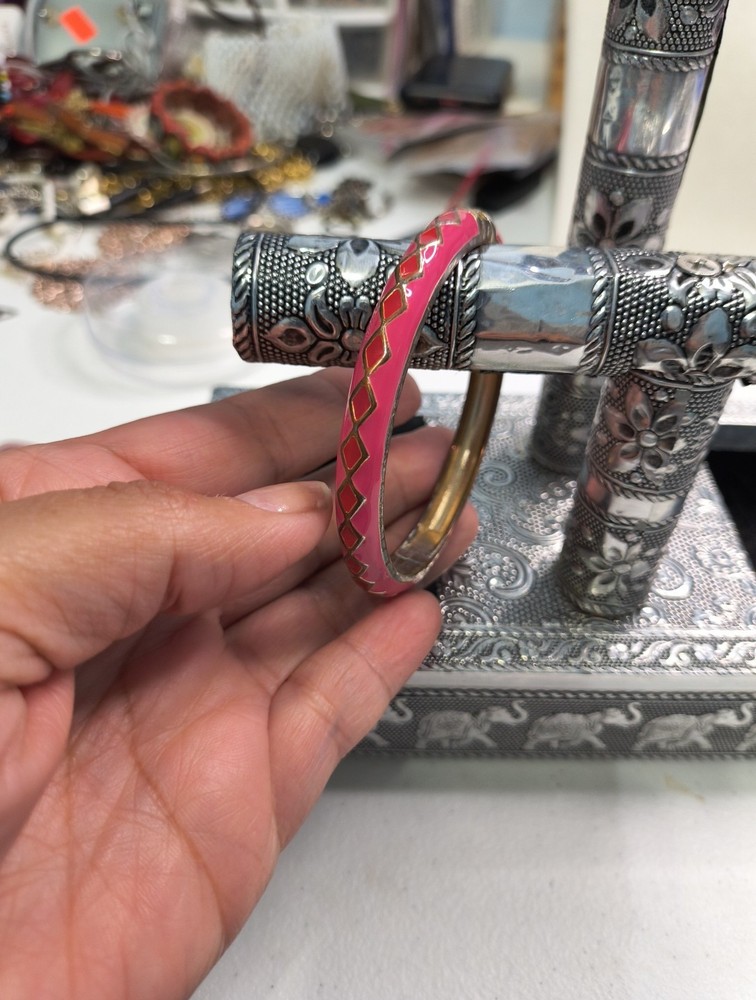 This is a pink and gold enamel bangle bracelet.