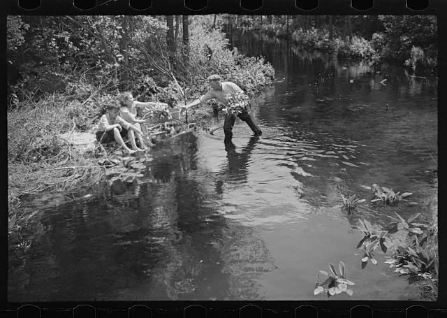 Photo:1930s Man Reaching to Boys in Creek Water Fishing Scene