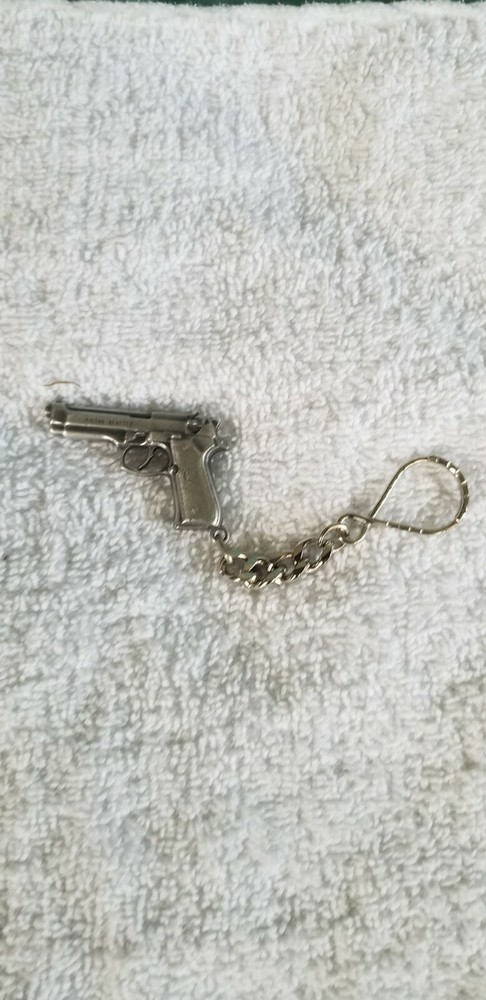 A metal key ring that looks like a Beretta 92. NEW in package